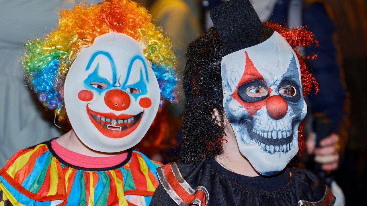 Children in vividly painted clown and skull masks at a Samhain (or Hallowe'en) Festival, one of Ireland's traditional autumn celebrations marking the turn of the Celtic year.
