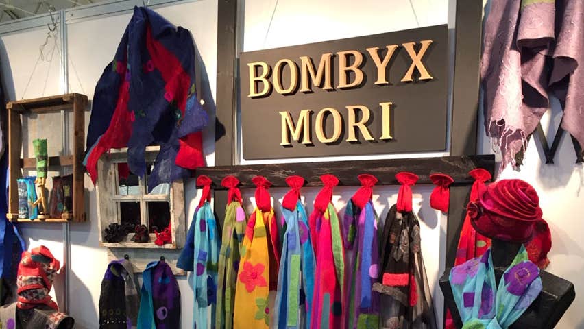 Interior of bombyxMORI Shop with a selection of colourful scarves on the walls around the shop's name