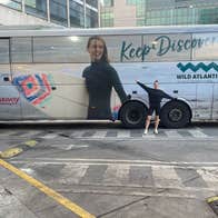 Woman posing in front of an Expressway Keep Discovering bus.