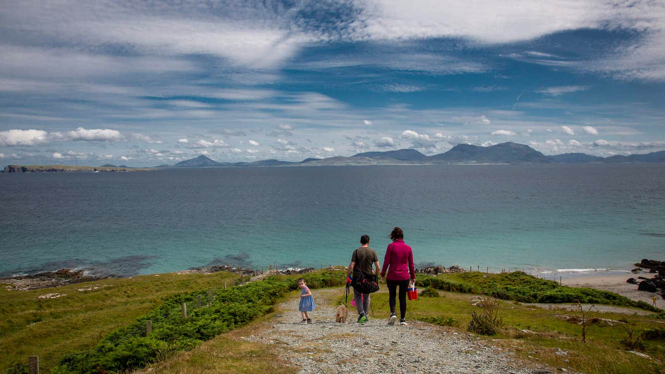 Family on a path to the sea with dramatic sky