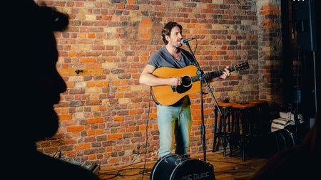 A singer with his guitar performing in a pub
