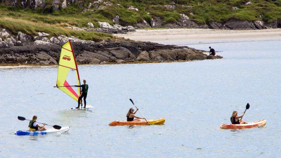 Three kayakers and 1 windsurfer in Derrynane