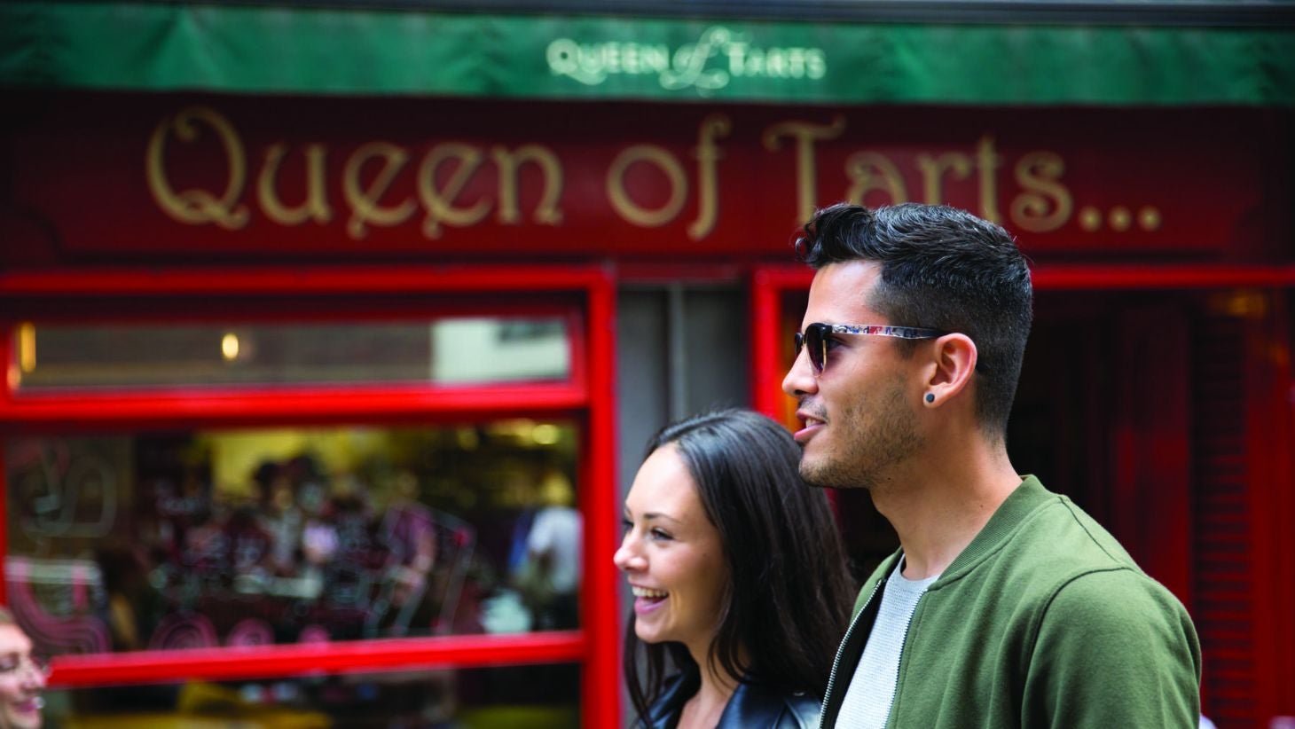 Friends walking past Queen of Tarts in Temple Bar, Dublin.