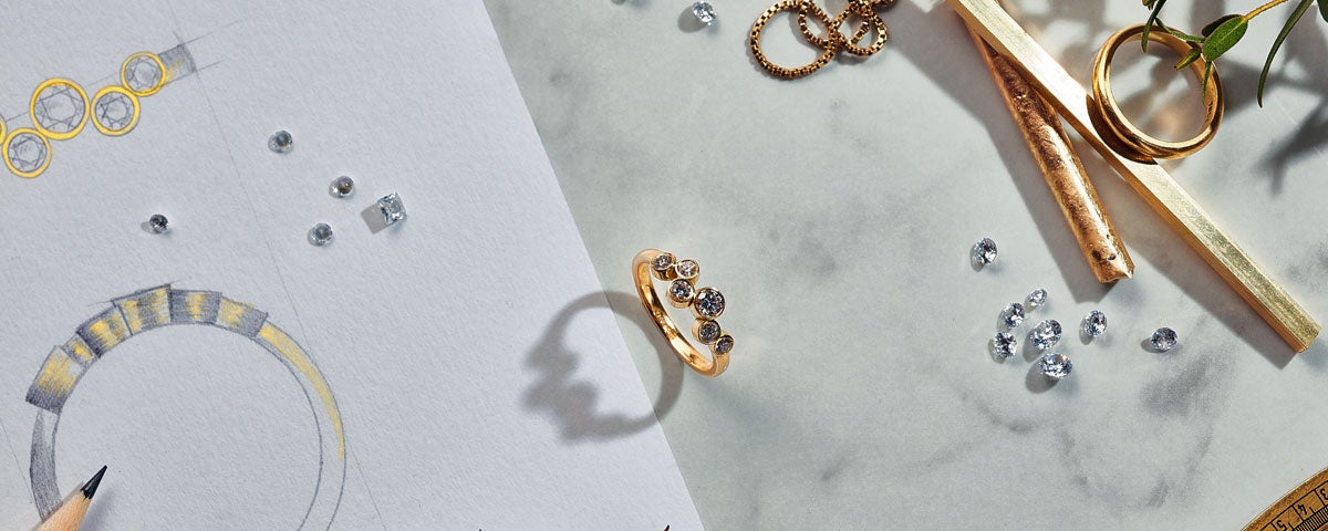 Image of six stone gold ring and a pencil sketch with loose diamonds around.