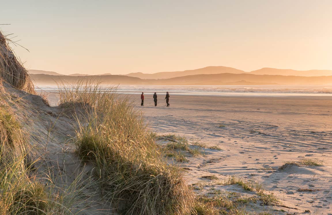 Sunset views and people walking at the beach in Co. Donegal