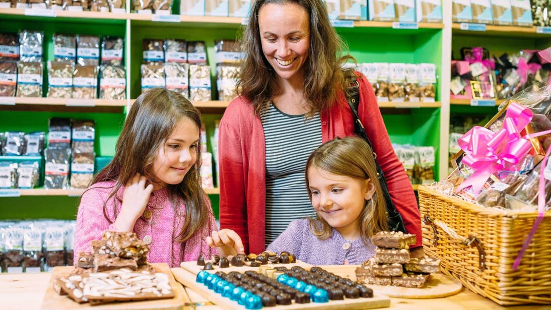 Two young kids and a woman looking at a tray of chocolates in Wilde Chocolates, Co. Clare