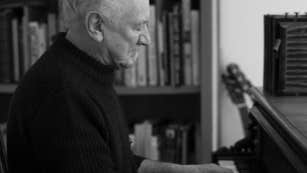 Side view of man playing a piano keyboard