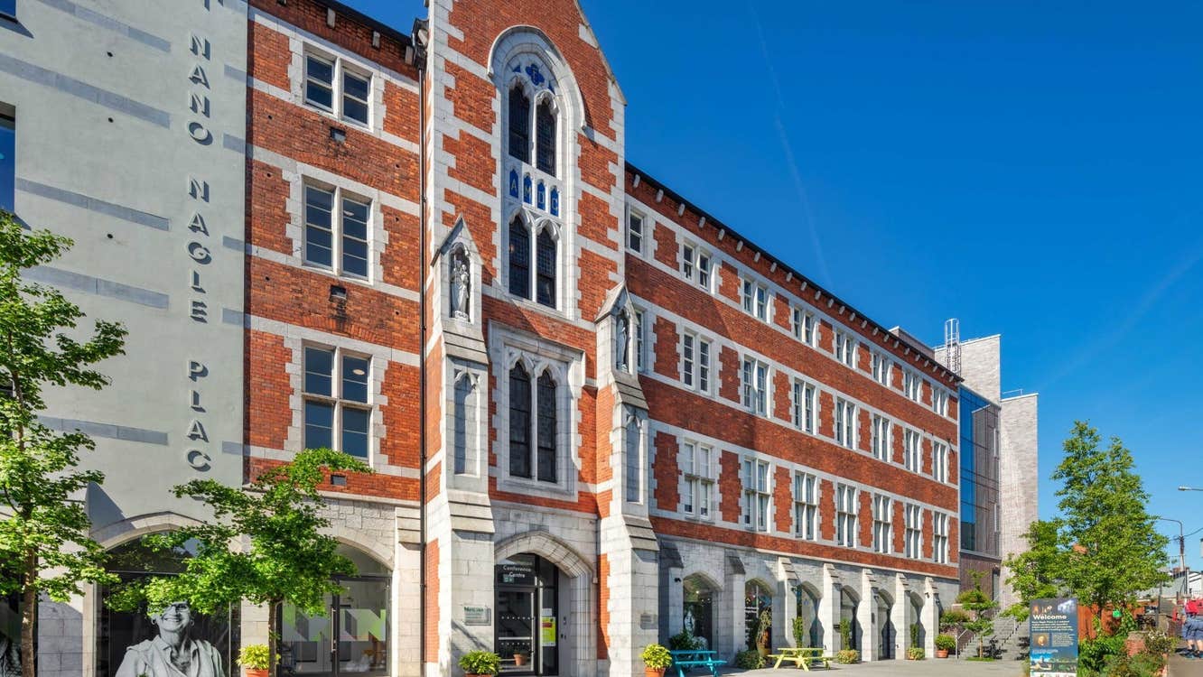 Exterior of red brick former convent building with some trees nearby