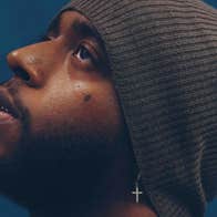 A side profile of man wearing a wooly hat, looking slightly upwards.