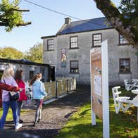 A family walking down the laneway to enter The Maria Edgeworth Visitor Centre