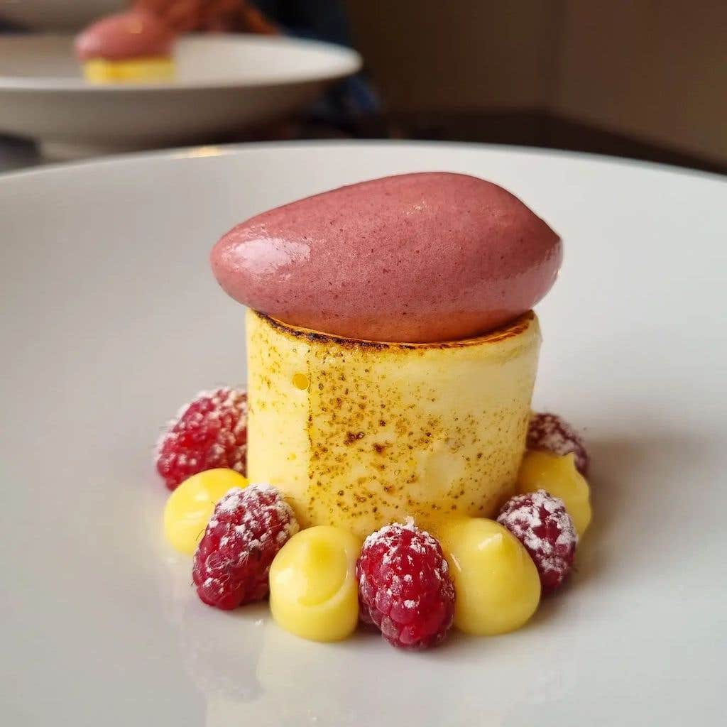 Luxurious dessert with custard and raspberry's served with a scoop of raspberry sorbet on top. 