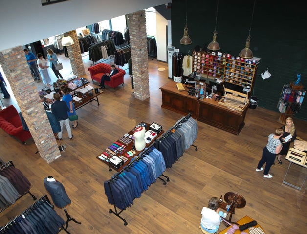 The interior of Celtic Tweed with customers inside the shop and tailored suit jackets on the display racks
