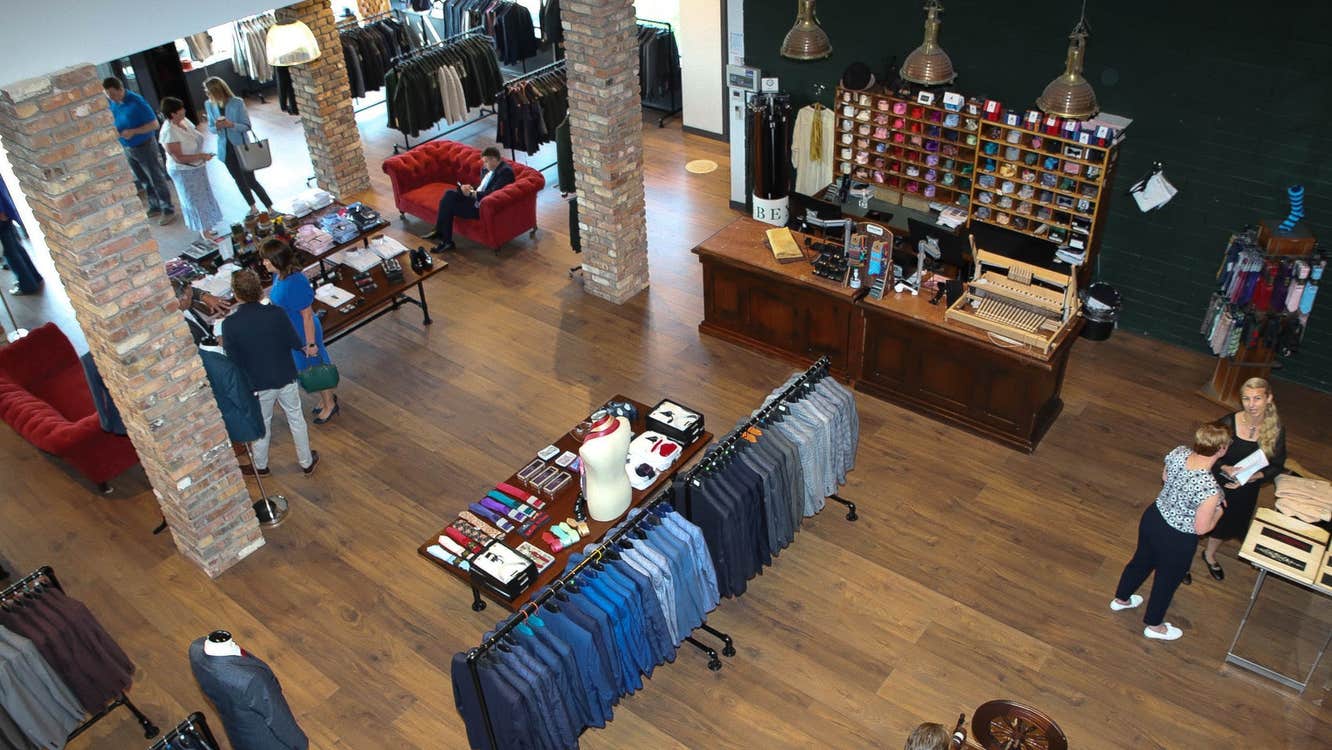 The interior of Celtic Tweed with customers inside the shop and tailored suit jackets on the display racks