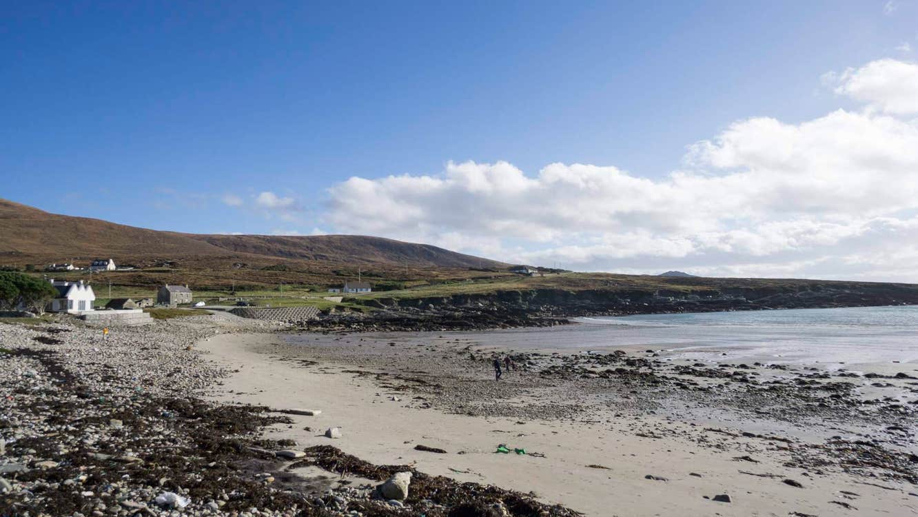 Stony beach with a house to the left and sea on the right