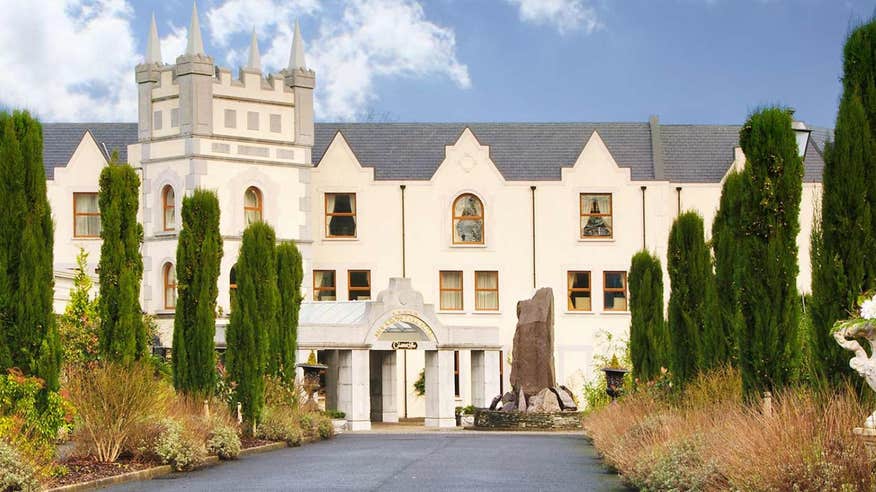 A driveway approaching Muckross Park Hotel, Killarney, Kerry flanked by trees on either side