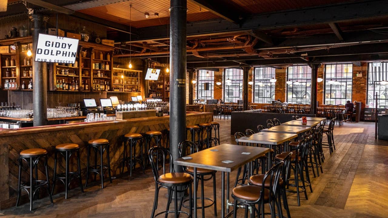 Interior of a bar with wooden counter, tables and seats