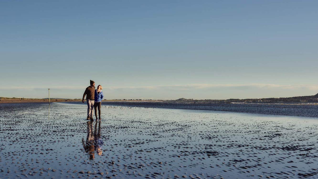 Couple walking on the beach at Bull Island, Dublin City, County Dublin