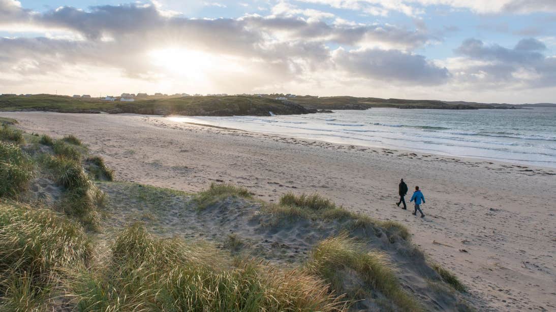 Two people walking down Carrickfinn Beach, Co. Donegal