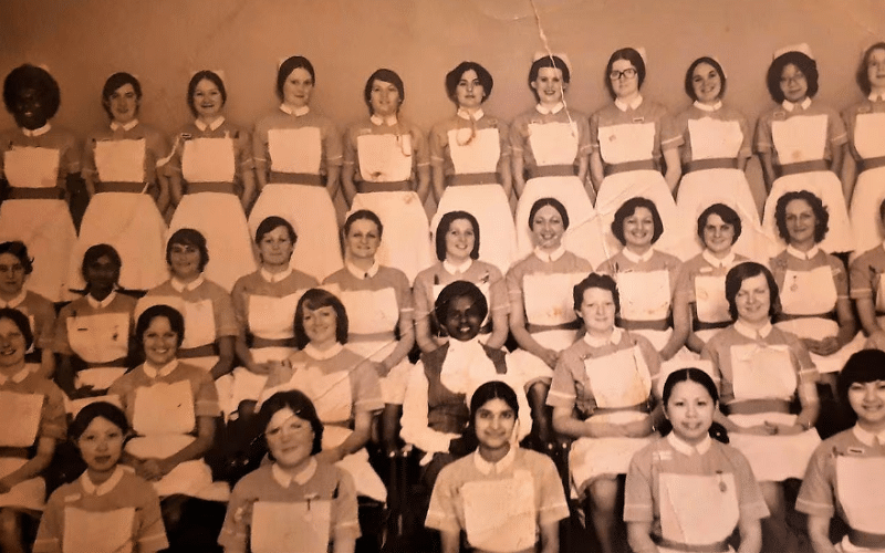 An old sepia photos of 4 lines of nurses posing for a photo from the 1950s