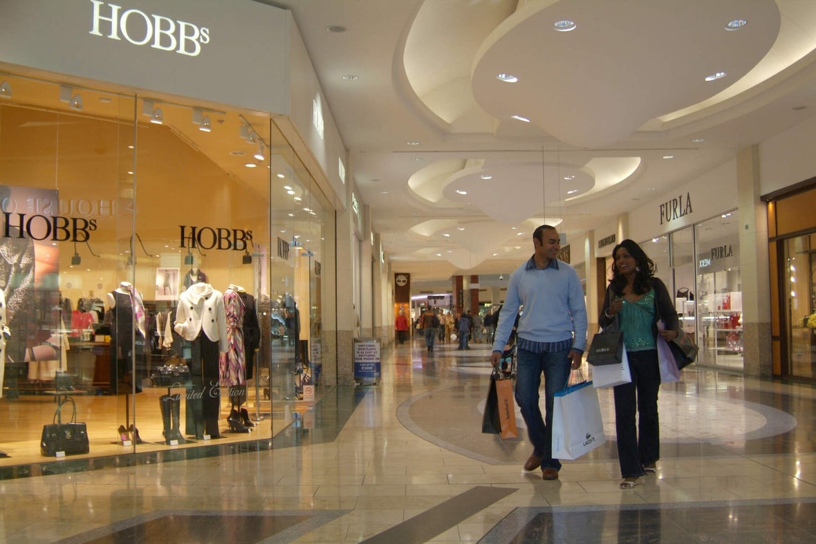 Couple with shopping bags walking through the interior of Dundrum Shopping Centre.