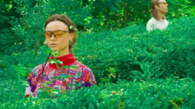 A photo of Sei Green standing in middle of hedges