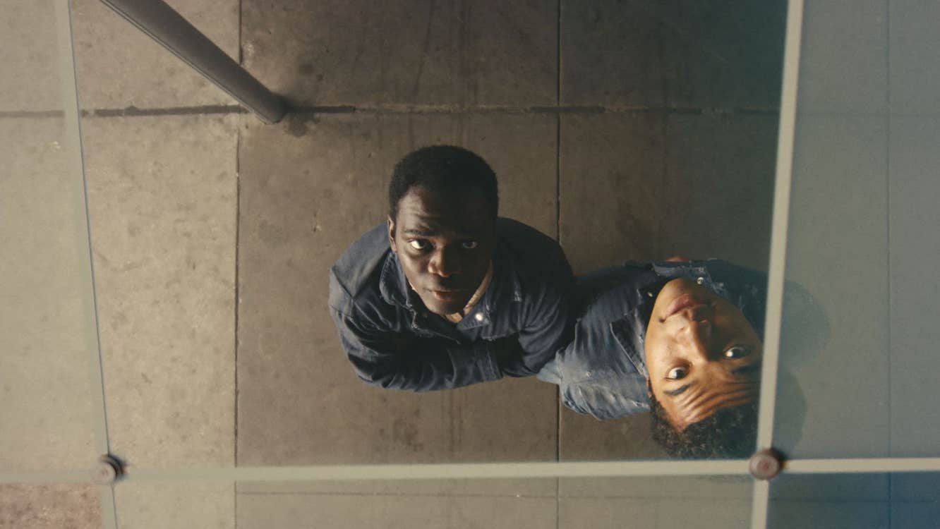 Two boys are looking up through a skylight.