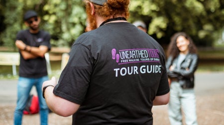 A guide wearing branded clothing of a tour company while giving a tour