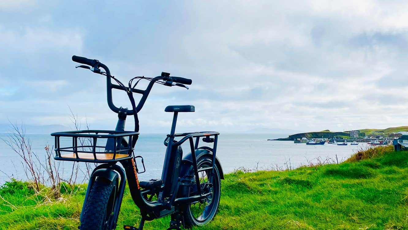 An ebike parked on grass beside the coast