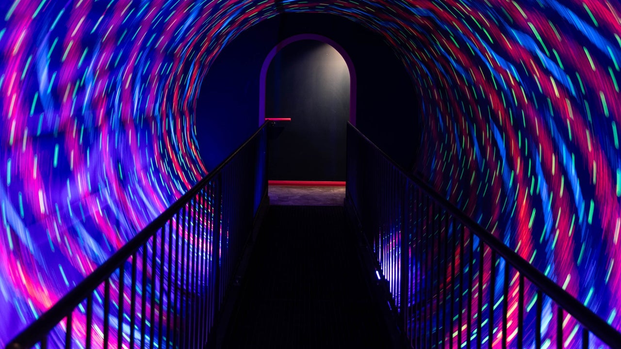 A dark walkway surrounded by a revolving tunnel of lights