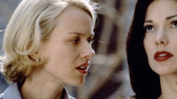 A woman is talking to another woman close beside her who is looking upwards.