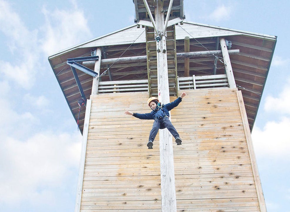 Child suspended on a climbing wall at Flynn Park