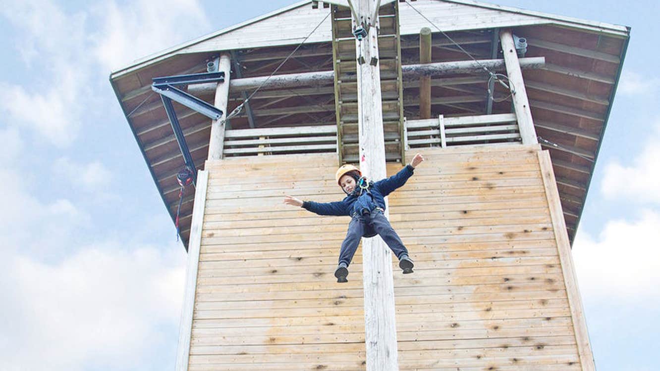 Child suspended on a climbing wall at Flynn Park