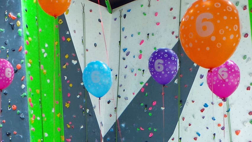 A variety of multi coloured balloons in front of the climbing wall