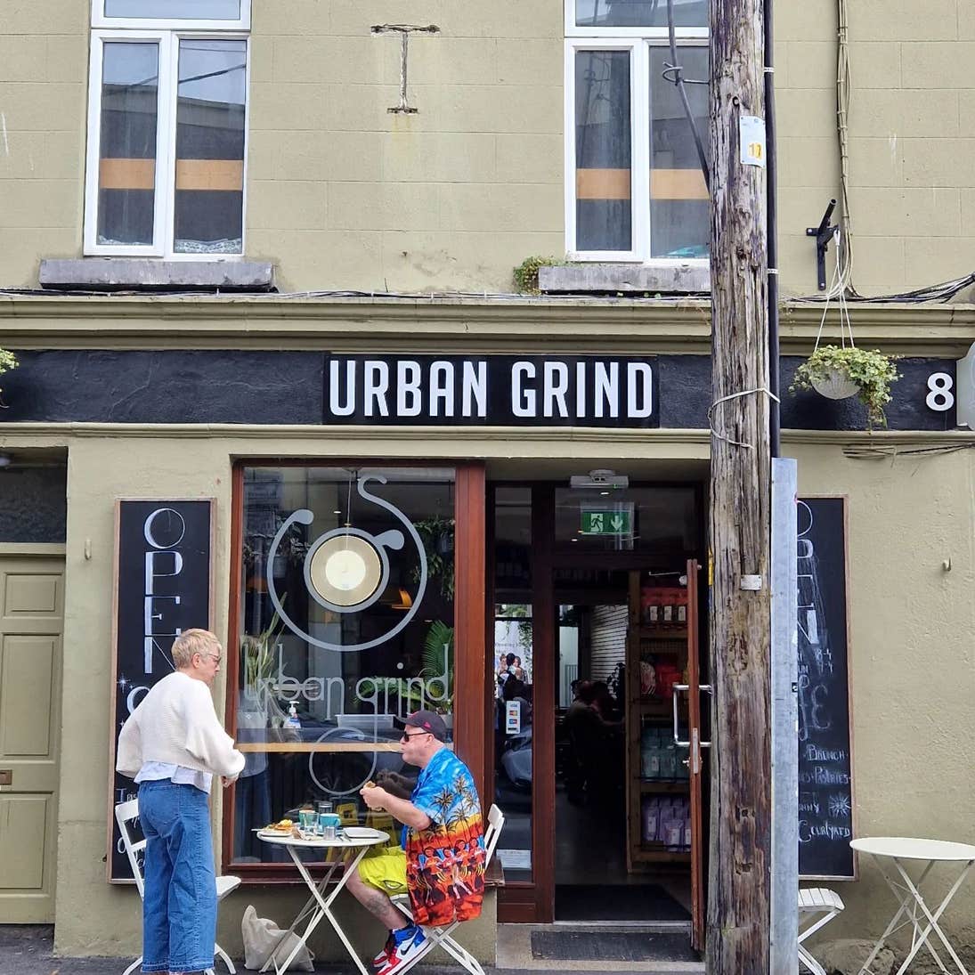 Two people at a table outside of Urban Grind Café in Galway city.