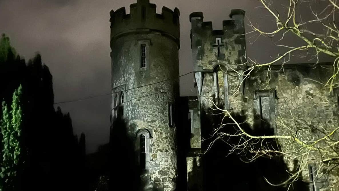 A large round castle turret lit up at night