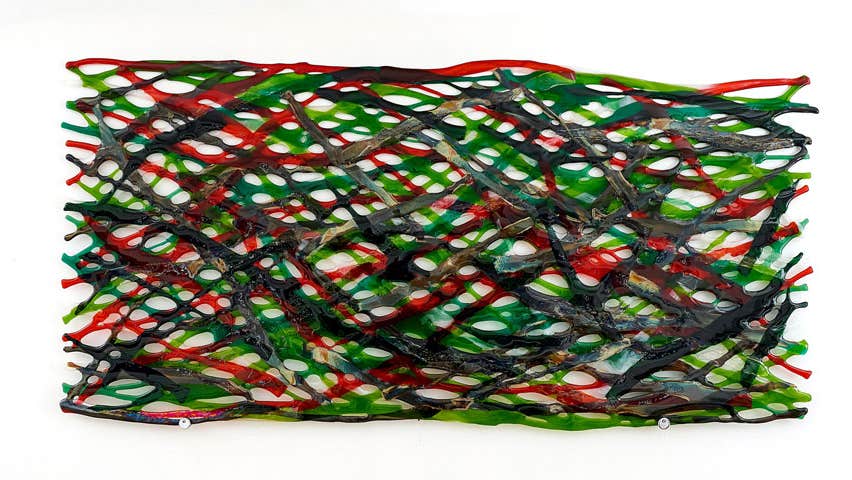 Image of green red and brown reeds intertwined in glass