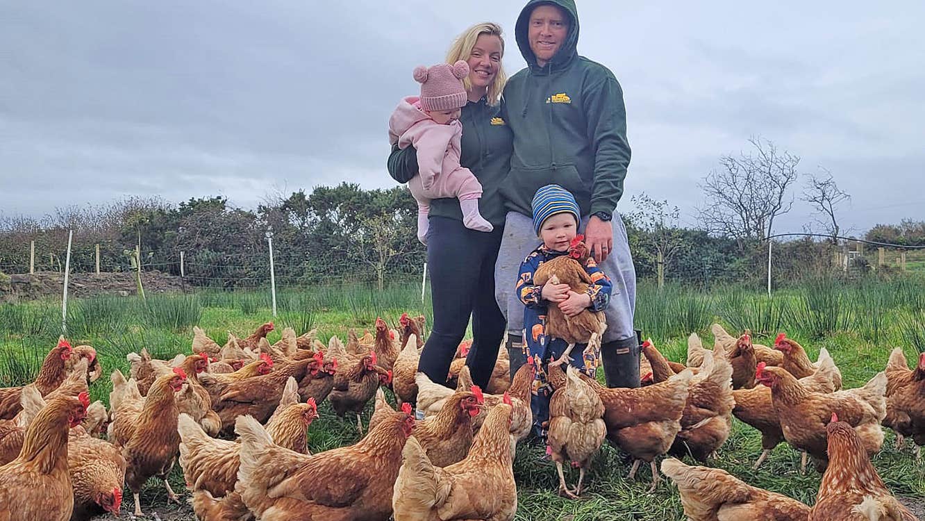 Mulroy Meadow Farm family standing among a flock of chickens in a field