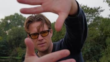 View of man with his hands held up at arms length framing his face.