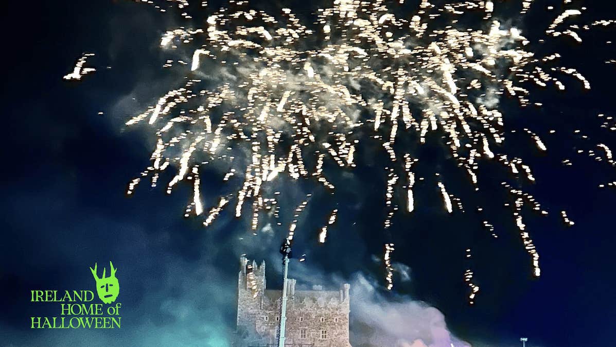 White fireworks at night exploding over a castle below