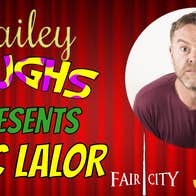 Bailey laughs Comedy Club Enniscorthy Eric Lalor, background of red stage curtains closed with text about the show in yellow, green and spotty with a round photo on the right of a man in a wine coloured top with quizzical expression. 
