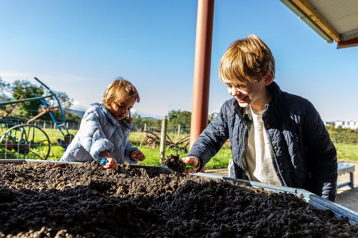 2 children enjoying a fun day at Airfield Estate with hands on activities.