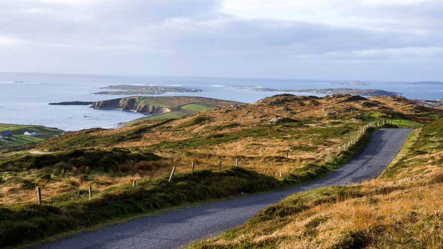 A country lane surrounded by green fields near the coast on Sky Road, Clifden, Galway
