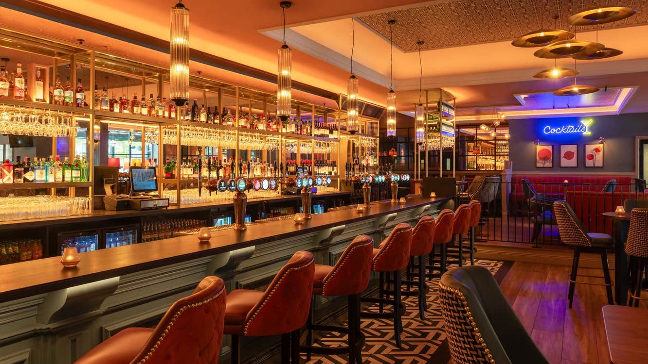 The interior of a bar with seats lined up along the counter