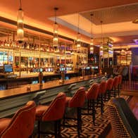 The interior of a bar with seats lined up along the counter