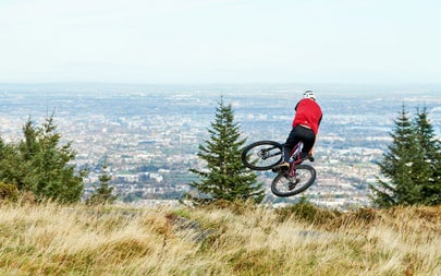 Ticknock Mountain Bike Trail Bike Rental and Guided Tours view of an airborne cyclist on a hill overlooking Dublin
