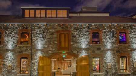 The exterior of a large building with old brick walls and large open doors