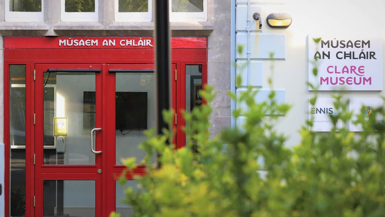 Exterior of a building with a bright red door and museum sign on the wall