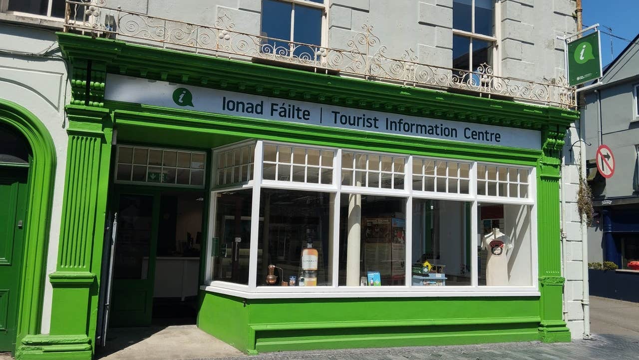 Exterior of a tourist office with the name in Irish and English above the windows
