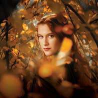 The Cunning Little Vixen, Irish National Opera, the face of a woman viewed through golden and orange autumn leaves