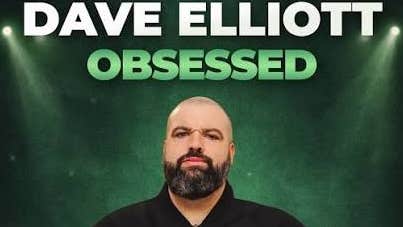 Comedian Dave Elliott, a slightly frowning man with beard and bald head.